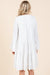 Back view of a woman wearing a white tiered boho dress with long flared sleeves, showcasing the flowy silhouette and soft fabric.