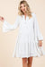 Happy woman in a flowy white tiered boho dress with flared long sleeves, perfect for casual summer wear